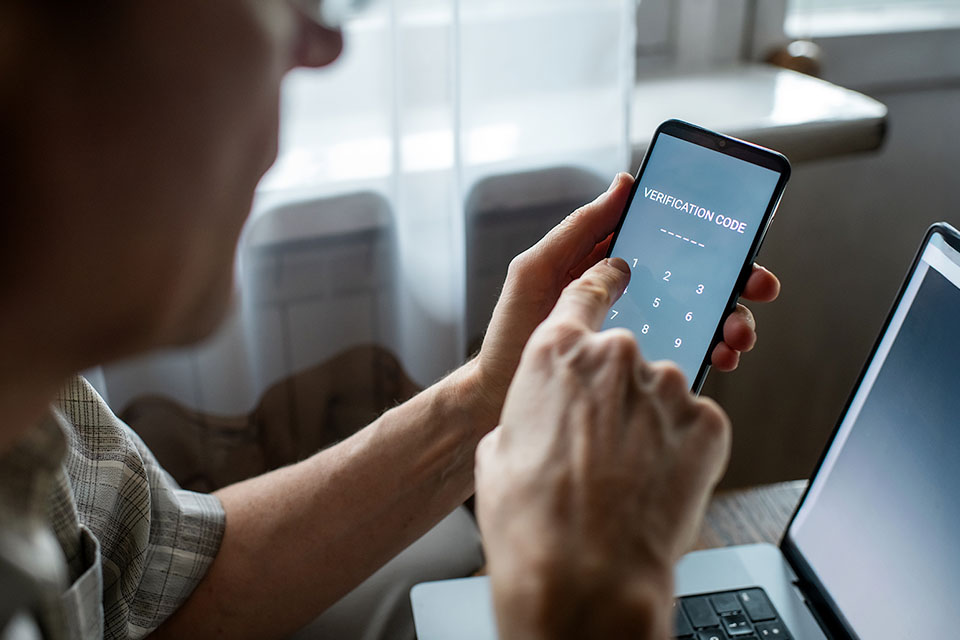 Man holding his phone and entering a verification code