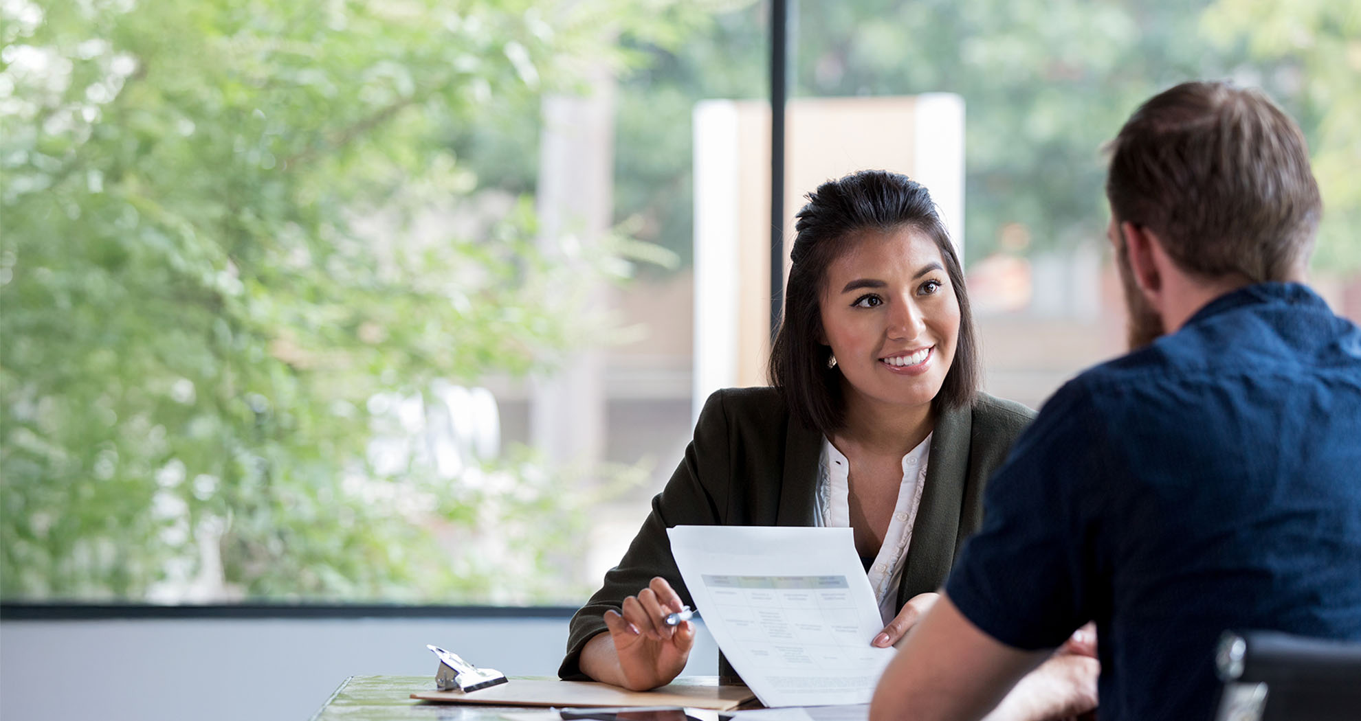 Business woman sitting at a table with a man reviewing documents