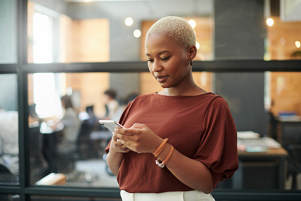 Woman in an office looking at her phone