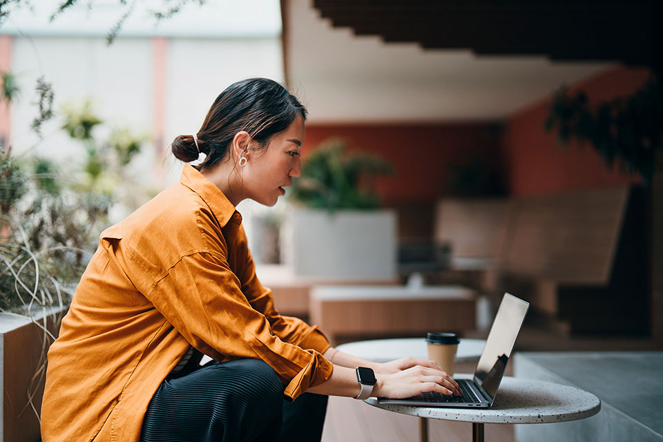 Woman sitting at a table using her laptop