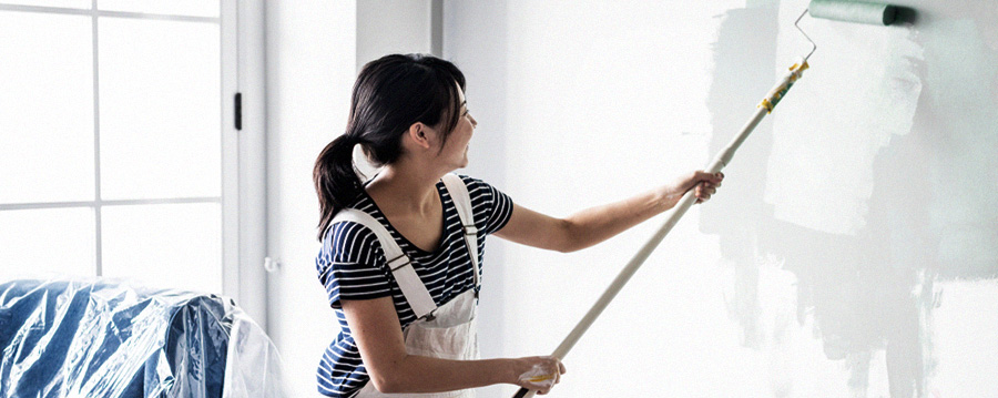 A woman painting the inside of her new home.