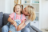 Mother embracing her daughter in the living room of their home.