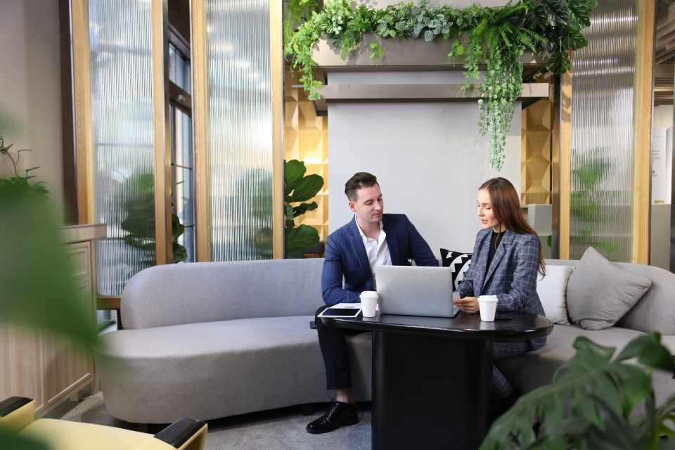 Customer consulting with a financial advisor using a laptop in an office.