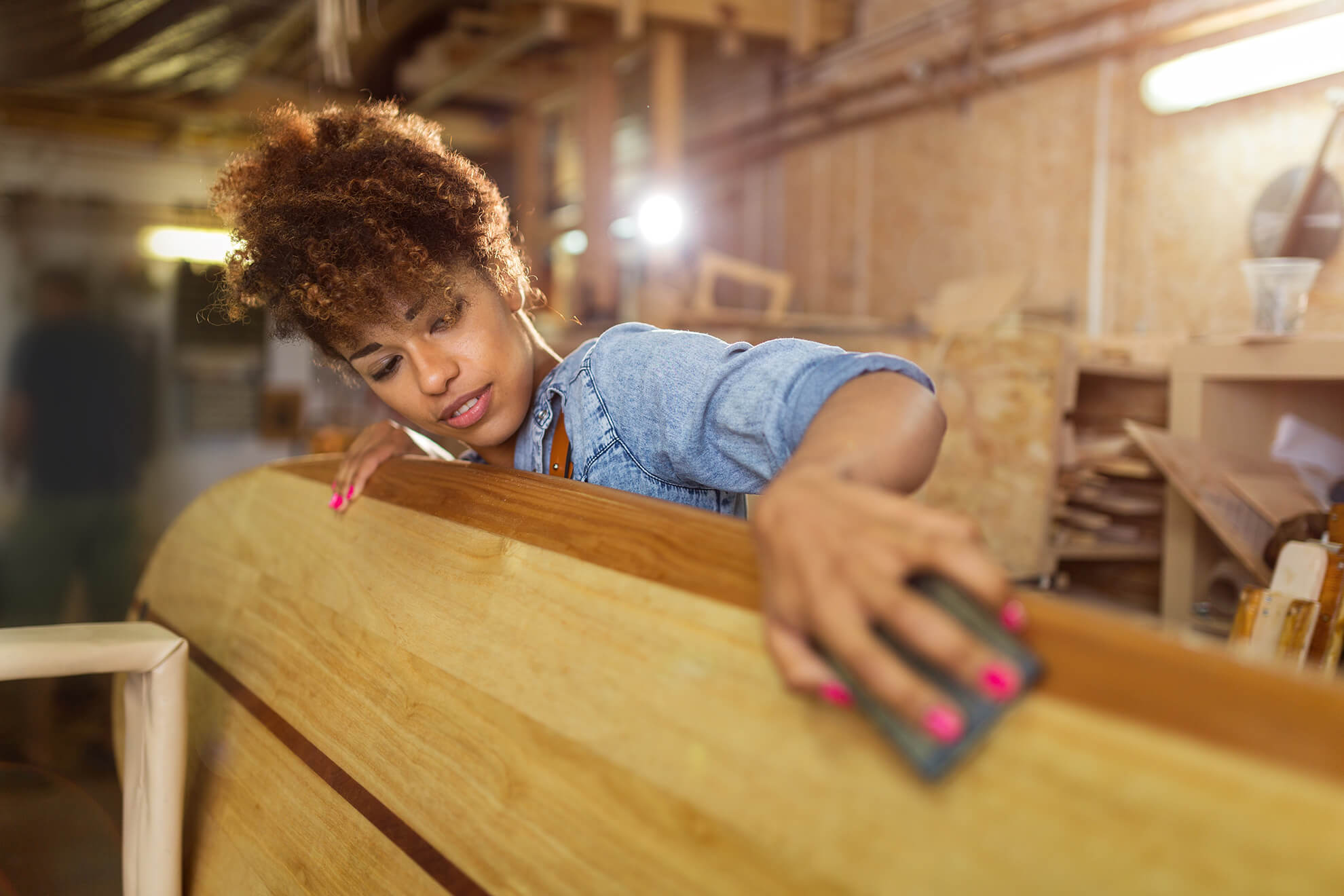 woman sanding wooden furniture