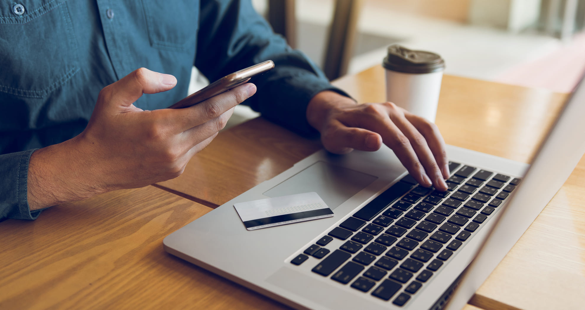 man using phone and laptop