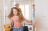 Little girl running into hotel room with parents wheeling suitcases behind her