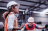 Woman wearing hi vis jacket and hard hat with building site in the background