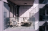 Glass apartment balcony with chair and stool in sunlight