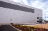 Large white warehouse with paved drive in foreground