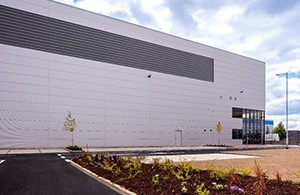 Large white warehouse with paved drive in foreground