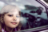 A close up of a young girl looking out a car window.