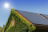 The top of a house with solar panels on a sunny day.