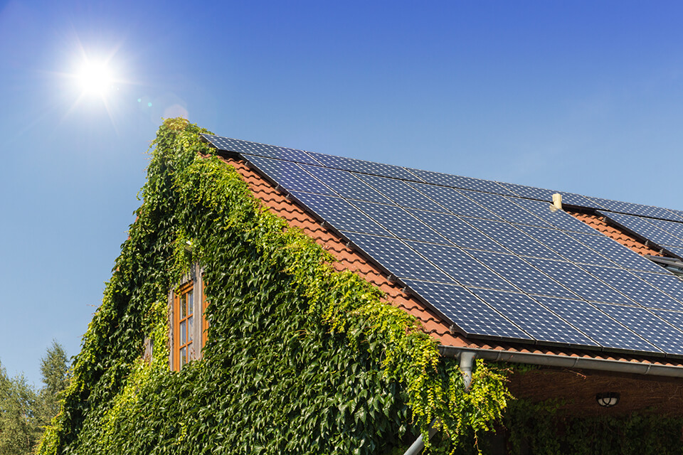The top of a house with solar panels on a sunny day.