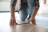 A man measuring the width of a floor board.