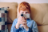 A close up of a boy on a sofa using a video camera .