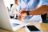Man at a desk looking at his smart watch.