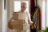 Man carrying boxes while looking at his phone.